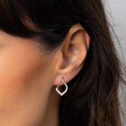 Close-up of an ear wearing a silver cut-out drop earring