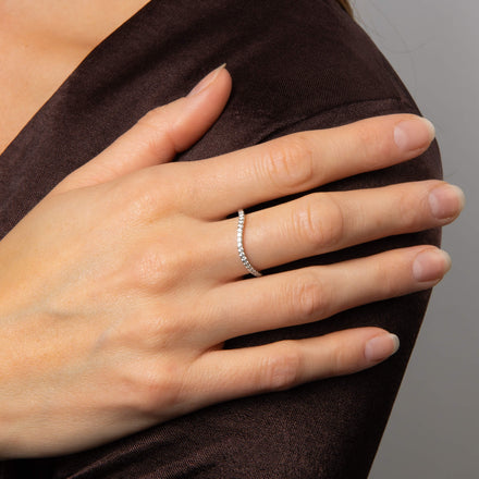 A hand resting on a shoulder, wearing a silver cluster ring