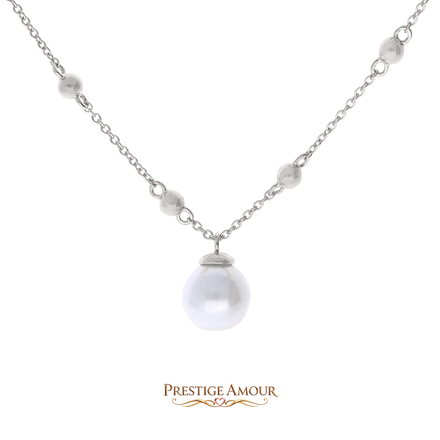 A woman wearing a silver teardrop halo pendant at the collarbone