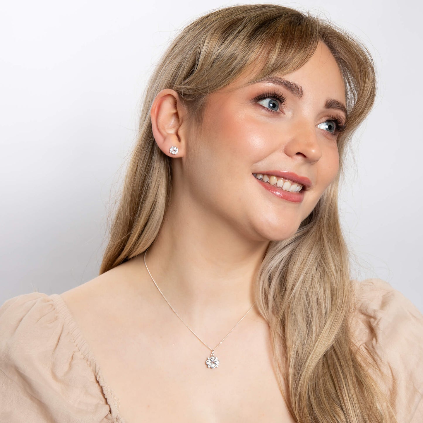 A woman wearing the Beginnings multi bezel-set zirconia pendant with matching pieces.