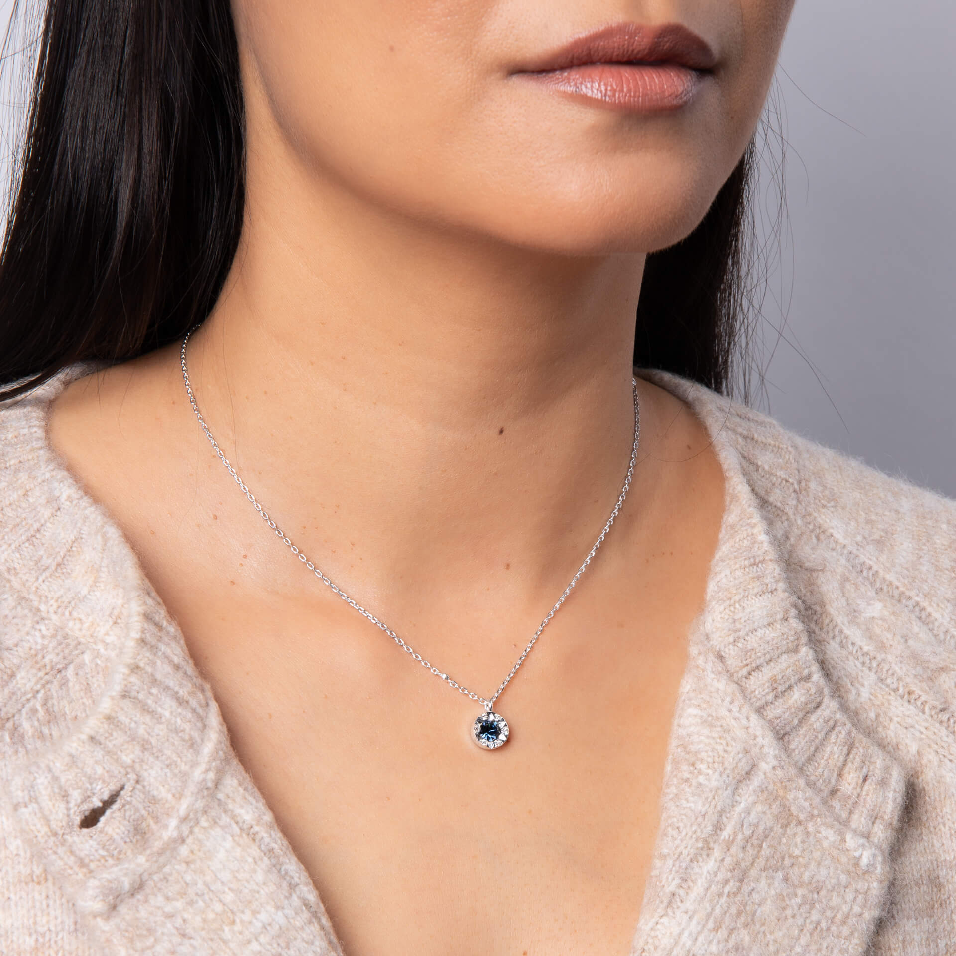 A woman wearing the Laura Ashley Bowen Star Crystal Necklace.