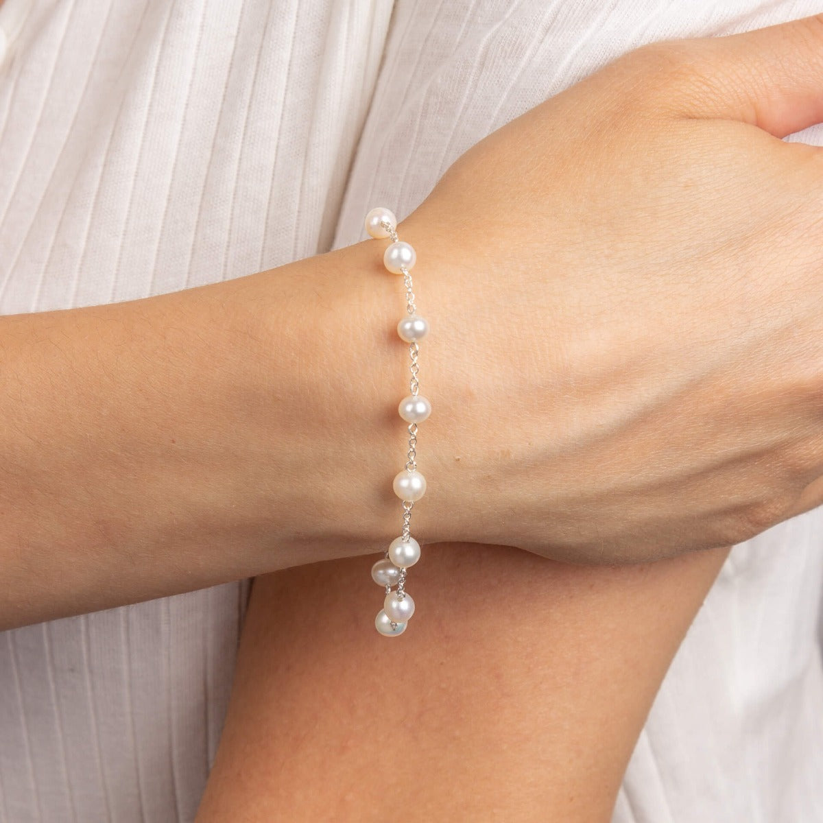 A woman wearing the Beginnings White Fresh Water Pearl Bracelet.