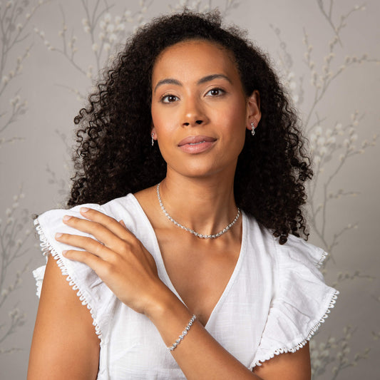 A woman wearing the Laura Ashley Tulip Chain Bracelet with matching pieces.
