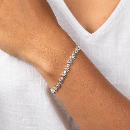 A woman wearing the Laura Ashley Tulip Chain Bracelet.