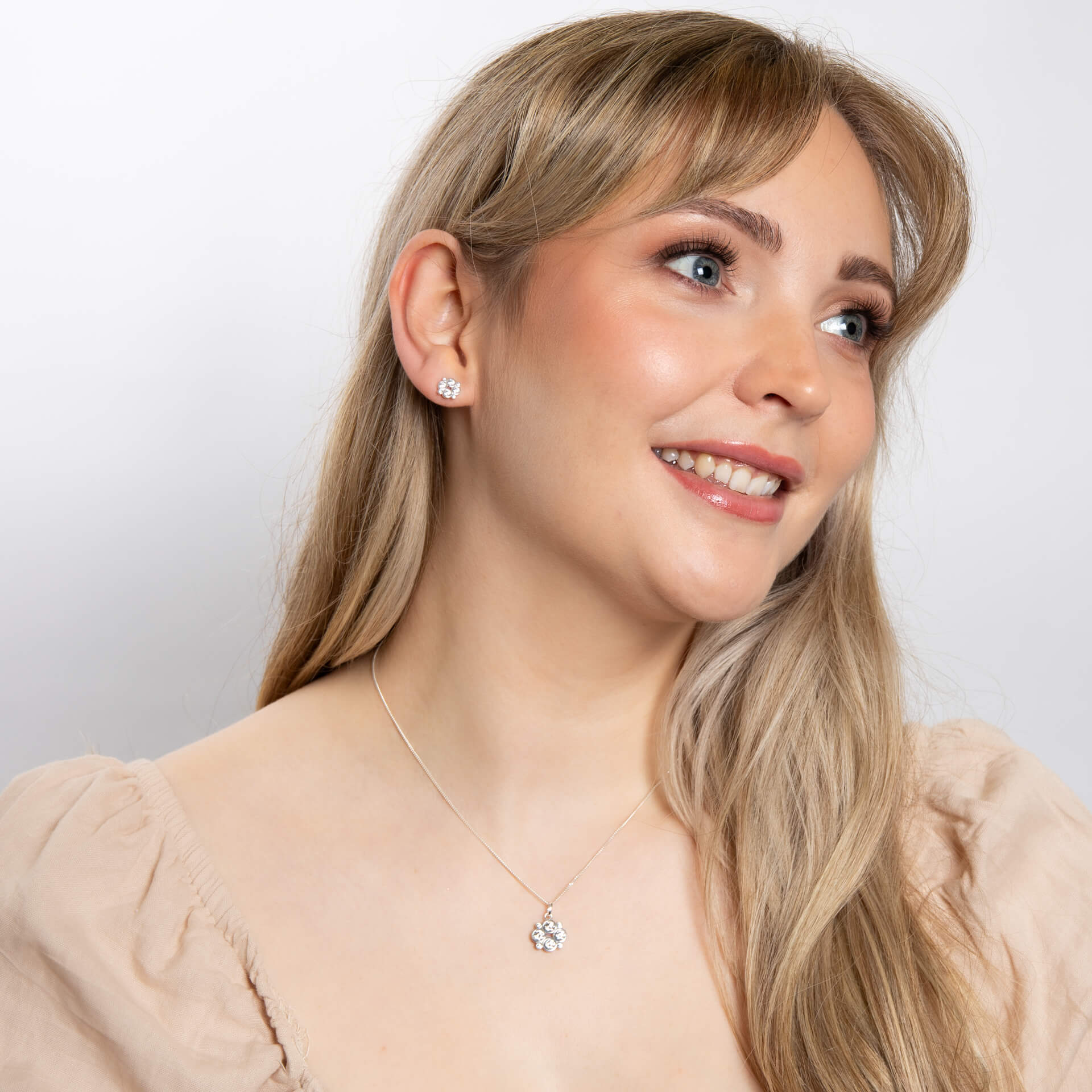 A woman wearing the Beginnings multi bezel-set zirconia pendant with matching pieces.