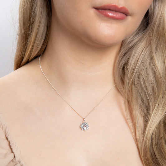 A woman wearing the Beginnings multi bezel-set zirconia pendant.